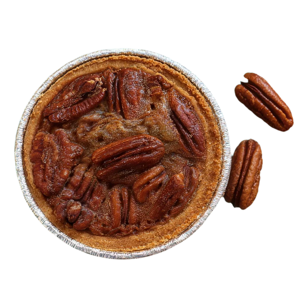 A mini pecan pie in its foil tin, from above