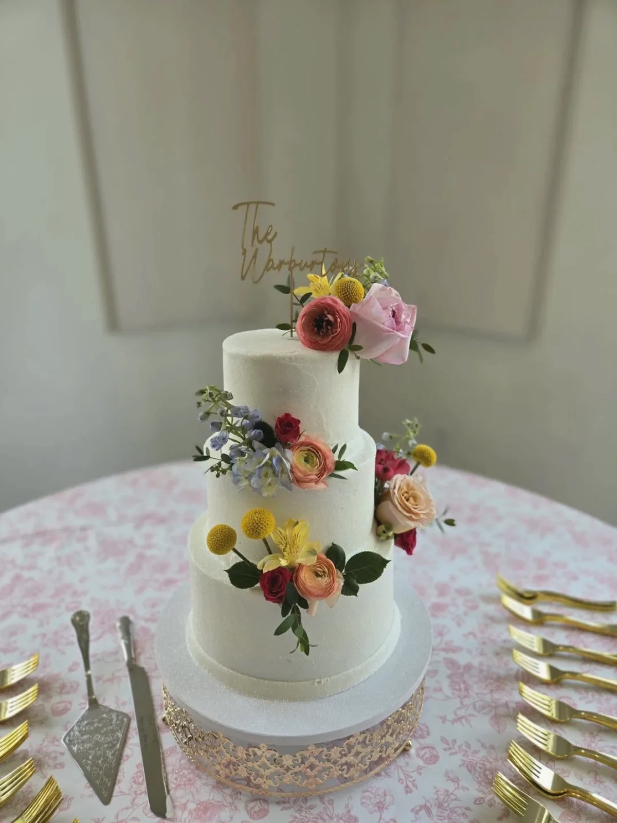 A white textured cake with bright wildflowers
